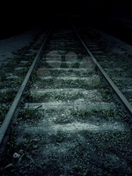 Old forgotten railroad in the dark, vintage background.