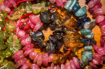 Natural multicolor tourmaline stone, chip beads background.