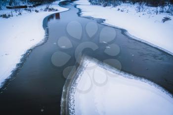 Snowy rural landscape with frozen river, winter background.