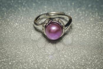 Luxury silver ring with natural freshwater pearl of purple color, macro.
