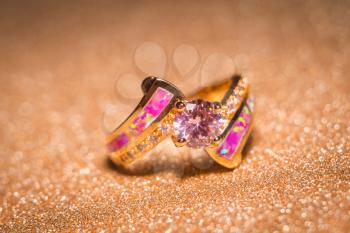 Rose gold ring decorated with pink zircon and fake opal.