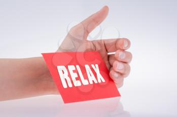 Relax wording written on red paper in hand