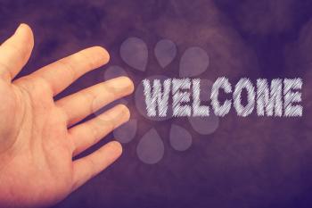 Hand making a welcome gesture on a dark background