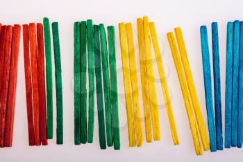 Sticks of various colors on awhite background
