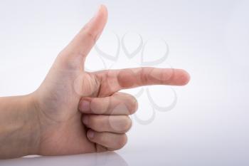 Hand making a gun gesture on a white background