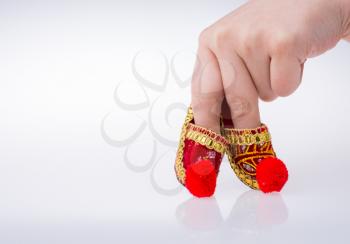 Hand holding traditional Turkish handmade  shoes on white background