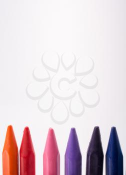 Crayons of various color on white background