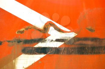 Arrow stencil on industrial metal surface. Scratched paint and rust macro background.