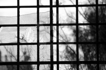 Broken window of an abandoned factory. Black and white.