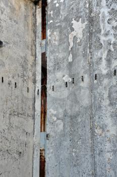 Concrete factory wall and rusty pipe. Industrial background.