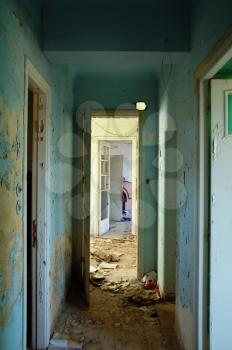 Peeling paint hallway and doors in abandoned building.