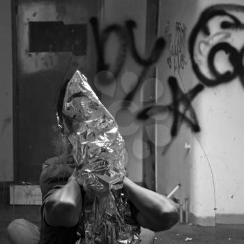 Obscured man and broken mirror in abandoned interior. Black and white.