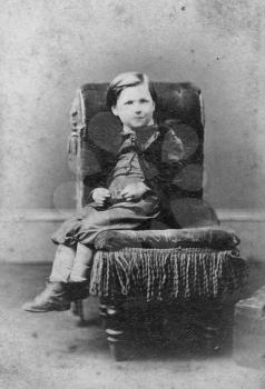 Portrait of boy on chair, black and white. Sourced from antique cabinet card vintage photograph created by A.D. Lewis, Newcastle on Tyne, UK, circa 1870.
