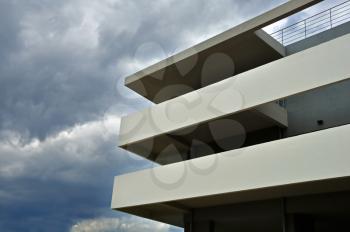 Stormy clouds and modern building facade and balcony. Architectural detail.