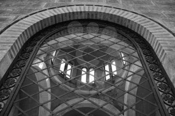 Arched window antique ironwork pattern and mausoleum dome. Black and white.
