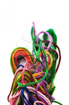 Colorful tangled yarn threads on white background. Selective focus macro.
