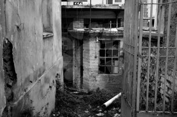 Rusty gate to an abandoned warehouse. Black and white.