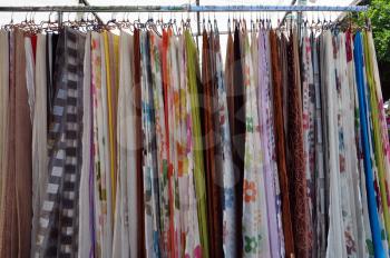 Colorful drapes for sale at street market. Abstract textile fabric background.