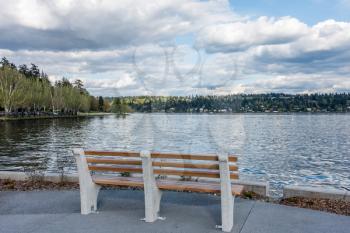 A view of Mercer Island with a bench in the foreground. Shot taken from Seward Park in Seattle.
