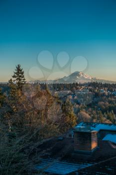 A veiw of Mount Rainier on a clear winter day with homes in the forefround. Shot taken from Burien, Washington.