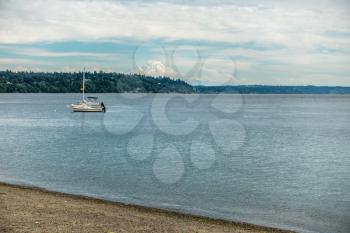 Two boats are anchored in the Puget Sound with Mount Rainier in the distance.