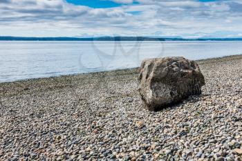 One rock sits on a bare shoreline at Lincoln Park in West Seattle, Washington.