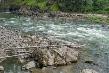 The Snoqualmie River flows past rocks creating white water.