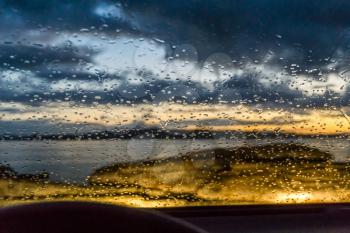 Raindrops cling to a car windshield at the end of the day in Burien, Washington.