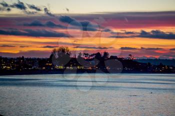 The sky is rich with colors as the sun sets at Alki Beach in West Seattle, Washington.