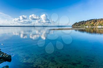 Puffy clouds are reflected in the water of the Puget Sound in Washington State.