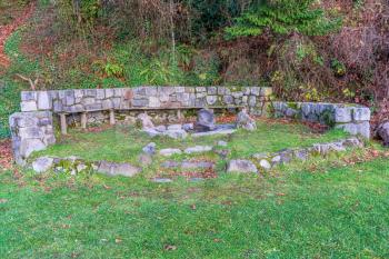 A stone wall surrounds a fire pit at Saltwater State Park in Des Moines, Washington.