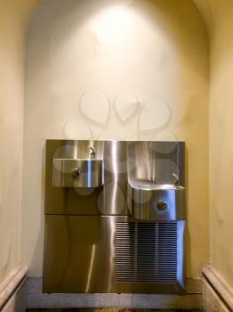 Public water fountain of stainless steel shiny clean refreshing silver reflections