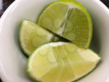 bright green fresh Lime slice in white bowl close up