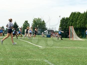 Lacrosse field with players on summer day with sun