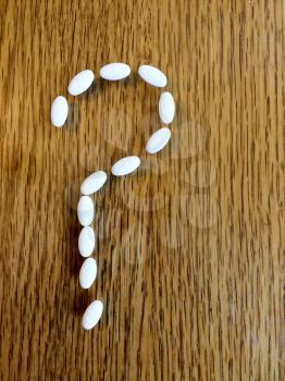 Medicine pills making question mark sign with open copy text space