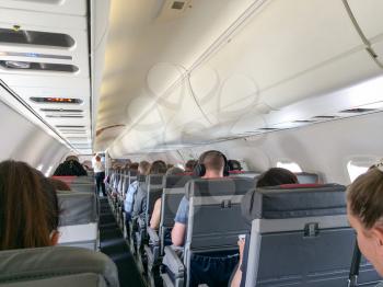 Inside airplane with passengers view from the rear seats