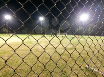 Night time soccer game at playing field outdoor with people and kids