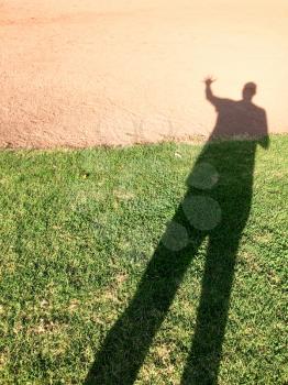 tall big single human man shadow on ground of grass and dirrt