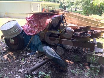 rusty antique ford car in backyard with spoked wheels junkyard