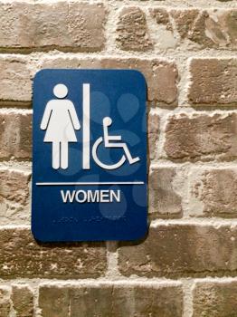 Women restroom blue white sign handicapped pictogram symbol on brick wall
