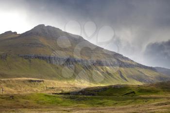 Dramatic landscape of Faroe islands showing pyramid mountains