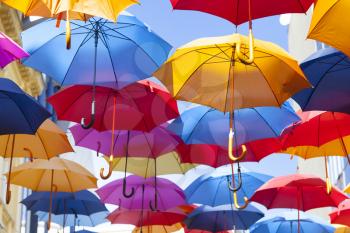Colorful umbrellas hanging in the air. Colorful umbrellas in the sky. Street decoration.