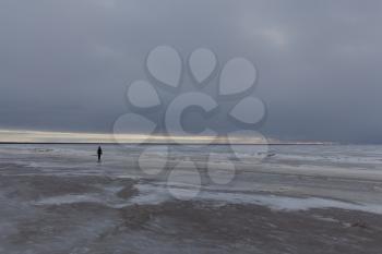 lonely silhouette on Parnu beach in winter, Estonia