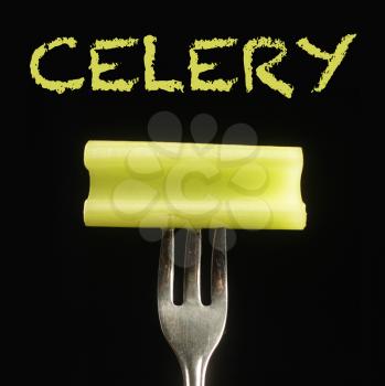 Celery on a fork on a black background