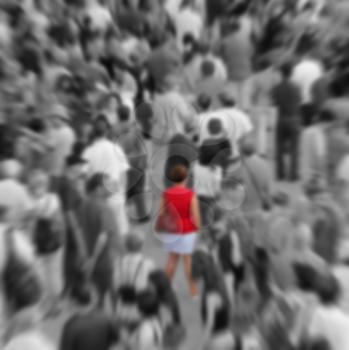 Blur background showing woman in red in a middle of a crowd in black and white.