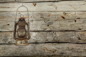 Old lantern hanging on a wooden barn wall. instagram style picture.