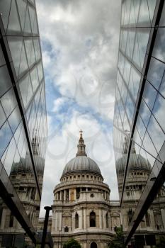 St-Paul's Cathedral and reflection in a mirror wall with a cloudy sky