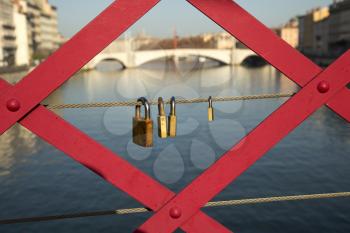 Three padlocks on a red bridge in Lyon, France
