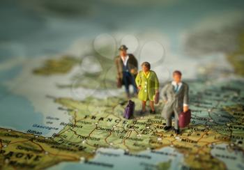 Mini people with luggage on a map, on Franc win Europe.