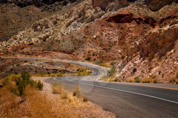 Waving road into Valley of fire in Nevada with mountains in background